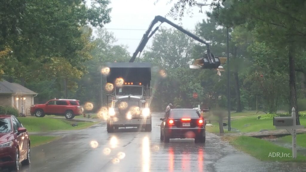 Truck picking up debris in the rain